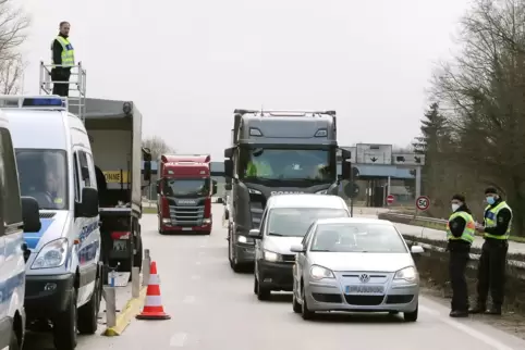 Auf einer Erhöhung kontrolliert ein Polizist die Dächer der Lkw. 