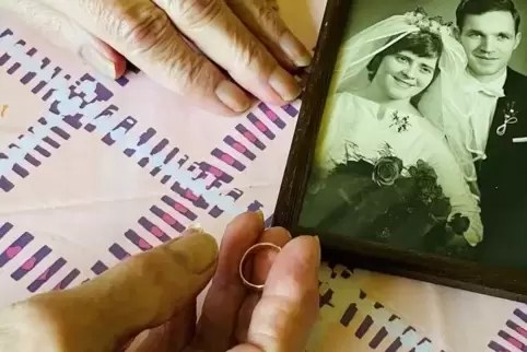  Die 79-Jährige aus Essen hält ihren neuen Ehering in der Hand. Daneben liegt ein Foto von ihr und ihrem Mann bei der Hochzeit 1