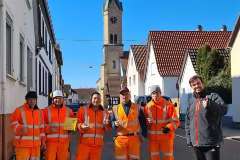 Ortsbürgermeister von Erlenbach Maik Wünstel mit den Arbeitern einer Kolonne des Baupartners Zener Telekom GmbH.