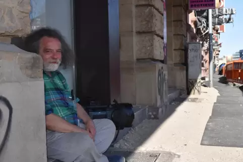 Der Obdachlose Peter sitzt mit einem Musikrekorder, seinem wichtigen Begleiter, auf der Straße. Beim Treff 88 in der Kriegsstraß