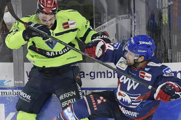 Craig Schira von den Adlern Mannheim (blauer Dress) im Duell mit dem Ingolstadter David Elsner.