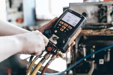 Das Foto zeigt die Dichtheitsprobe eines Klimageräts durch einen Servicetechniker. Die Tests sind gesetzlich vorgeschrieben.