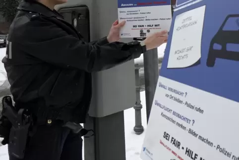 Blickfang an neuralgischen Punkten: Projektverantwortliche Valerie Renz beim Aufhängen der Plakate. 