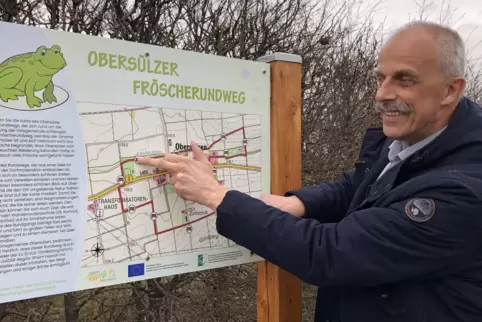 Ortsbürgermeister Andreas Lehmann erläutert den fast fertigen Frösche-Rundweg anhand einer Hinweistafel, die am Parkplatz des SV