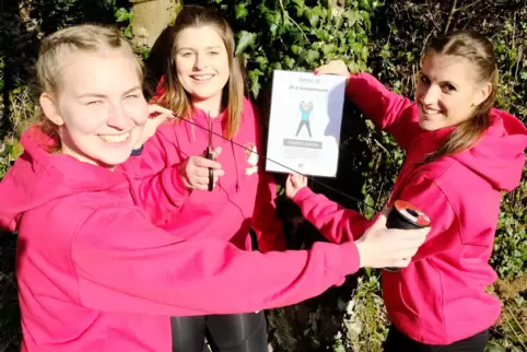 Los geht’s: Jasmin Knapp, Chantal Franze und Lena Hettrich (von links) vom TV Rieschweiler hängen im Wald Schilder für den Fitne