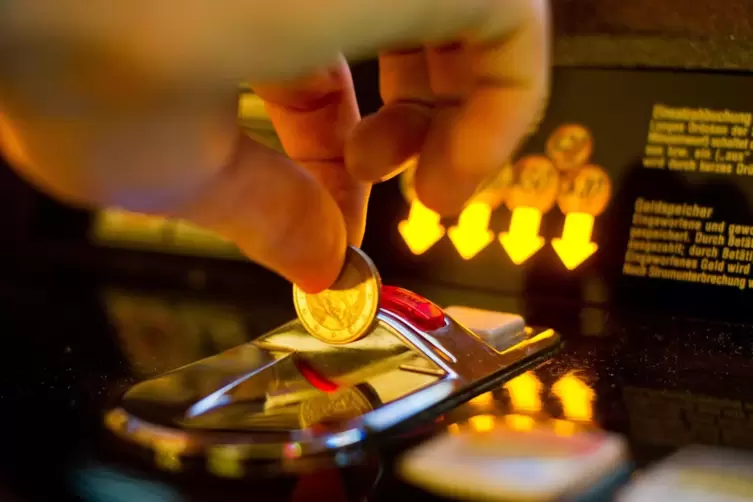 Eine Münze landet in einem Spielautomaten.