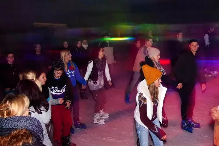 Und schlitternde und flirtende Jugend bei der Eisdisco.