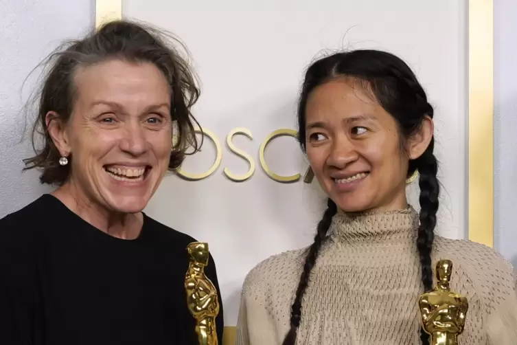 Glückliche Siegerinnen: Frances McDormand (links9 mit ihrem dritten Schauspiuel-Oscar, für „Nomadland“, und ihre Regisseurin Chl