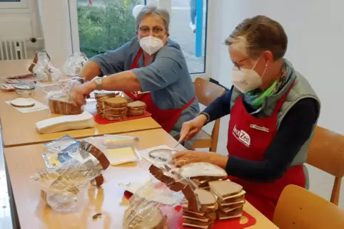 Zwei Seniorinnen schmieren die Brote.