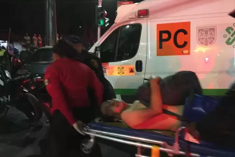 Rettungskräfte transportieren einen Verletzten auf einer Trage zu einem Krankenwagen