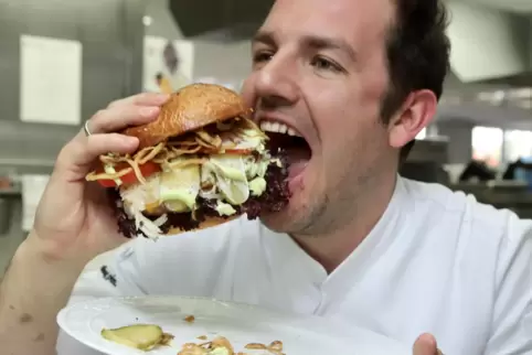 Und rein damit: Krone-Chefkoch Fabio Daneluzzi genießt seinen Saumagenburger.