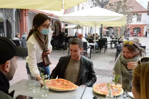 Die ganze Familie hilft mit: Hier serviert Raffaella Runco Pizza für Gäste.