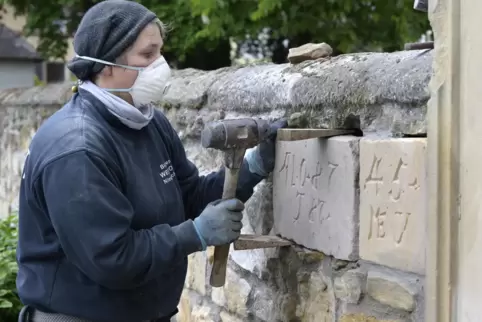 Steinerne Zeugnisse: Janet Weisbrodt-Barth fügt die Repliken in die Friedhofsmauer ein.