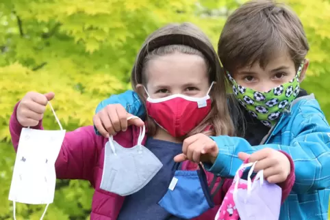 Die sechsjährigen Zwillinge Elly und Lenn mit einer Auswahl ihrer Masken, die Stoffmasken tragen sie am liebsten.