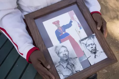  Uruanaani Scara Matundu, ein Vertreter der Herero-Gemeinde, zeigt in einem Park in Windhuk Fotos seiner Vorfahren.