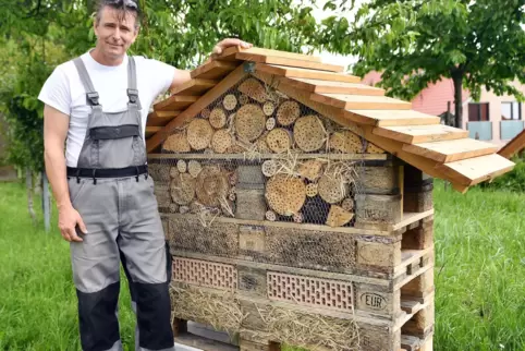Gemeindearbeiter Zbyszek Paradoski neben einem Insektenhotel.