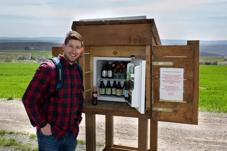 Einfach ein Getränk aus dem Kühlschrank am Wegesrand holen: Verbandsgemeinde-Mitarbeiter Johannes Helf macht es bei Wörsbach vor