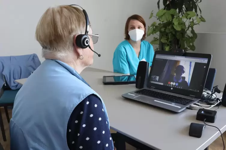 Eine Bewohnerin des Rülzheimer Pflegeheims im Video-Gespräch mit ihrem Arzt Jonas Hofman-Eifler. Im Hintergrund beobachtet Alten
