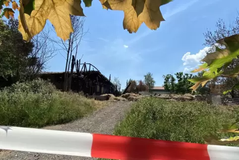 Der Brandort ist abgesperrt: Links im Bild ist der Stall zu sehen, der bei dem Feuer zum Teil beschädigt wurde. Rechts stand die