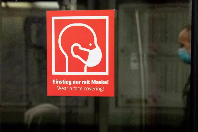 Ein Schild an einem Zug weist auf die Maskenpflicht hin. 