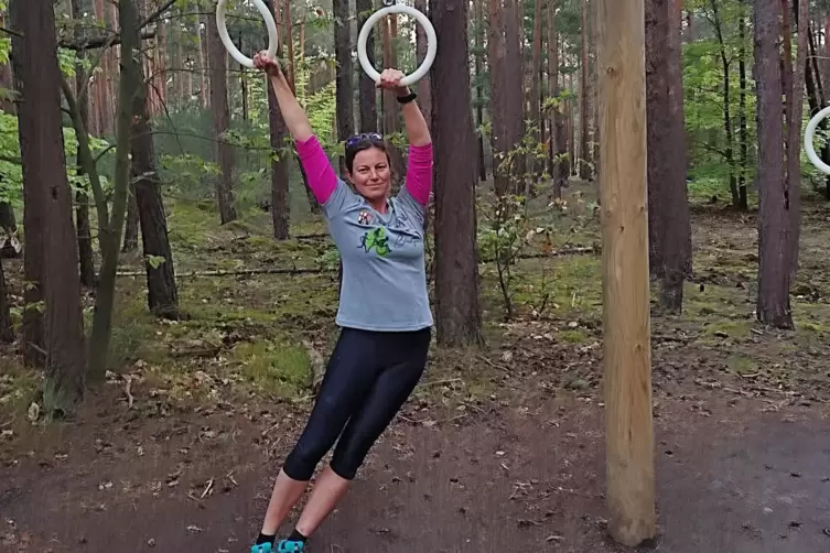 Bewegungsmanagerin Britta Blankenfuland zeigt eine der Übungen am Trimm-dich-Pfad.