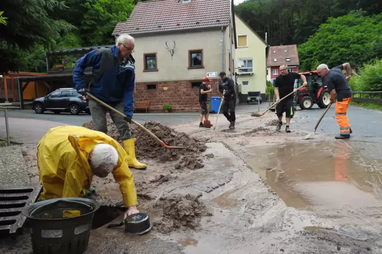 Anwohner der Neutalstra&szlig;e in Lindenberg schaufeln den Schlamm weg. 