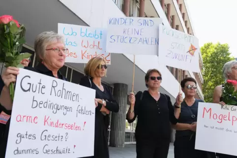Erzieherinnen halten während einer Demonstration gegen die Neufassung des Kita-Gesetzes nahe des Landtags Rheinland-Pfalz Plakat