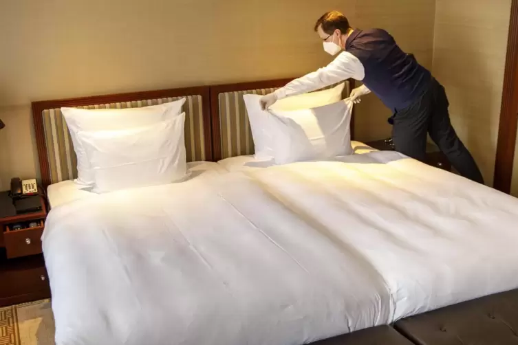 Ein Hotelmitarbeiter kontrolliert das Bett in einem Hotelzimmer. Die Corona-Krise hat die Branche schwer mitgenommen. 