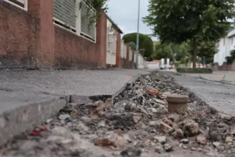 Im Gehweg in der Jakob-Kautz-Straße in Bockenheim fehlt in großen Teilen der Unterbau, wie durch die Verlegung der Glasfaserkabe