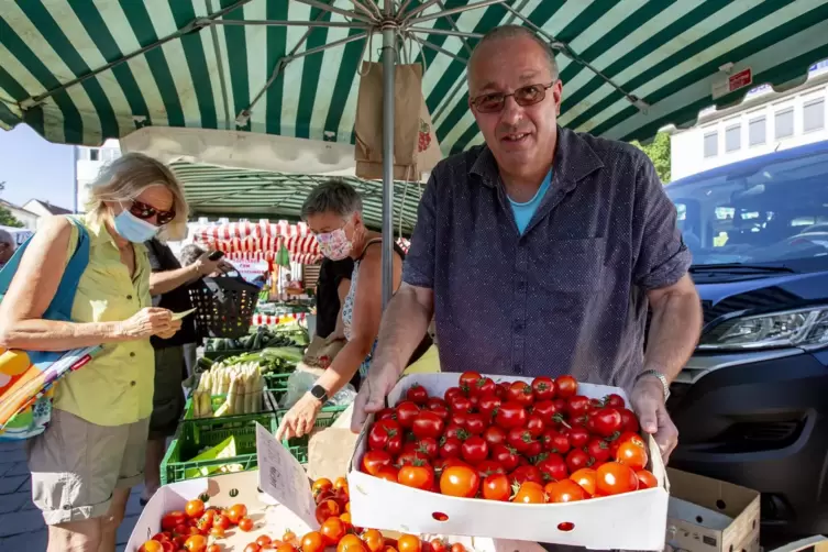 An seinem Obst- und Gemüsestand zeigt Jürgen Müller seine Tomaten aus eigenem Anbau.