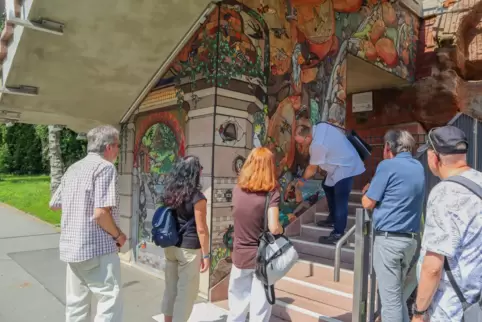 Gästeführer Herbert Pfeffer zeigt den Teilnehmern der offenen Stadtführung „Pirmasens in 741 Stufen“ die Mosaiken der Vogeltrepp