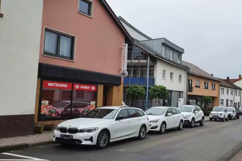 Firmenfahrzeuge parken in einer Reihe in der Hauptstraße. Die Folge: Vor den Geschäften fehlen Parkplätze für Kunden. 