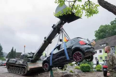 Soldaten der Bundeswehr bergen mit einem Pionierpanzer Dachs ein zerstörtes Auto bei den Aufräumarbeiten der schweren Unwettersc