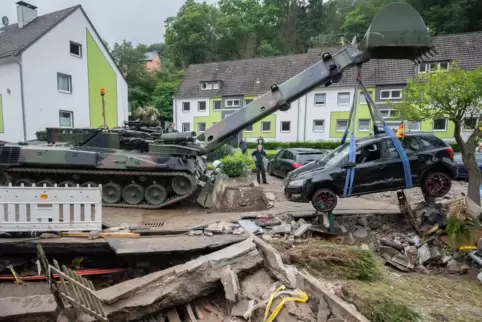 Soldaten der Bundeswehr bergen mit einem Pionierpanzer Dachs ein zerstörtes Auto bei den Aufräumarbeiten in Hagen.