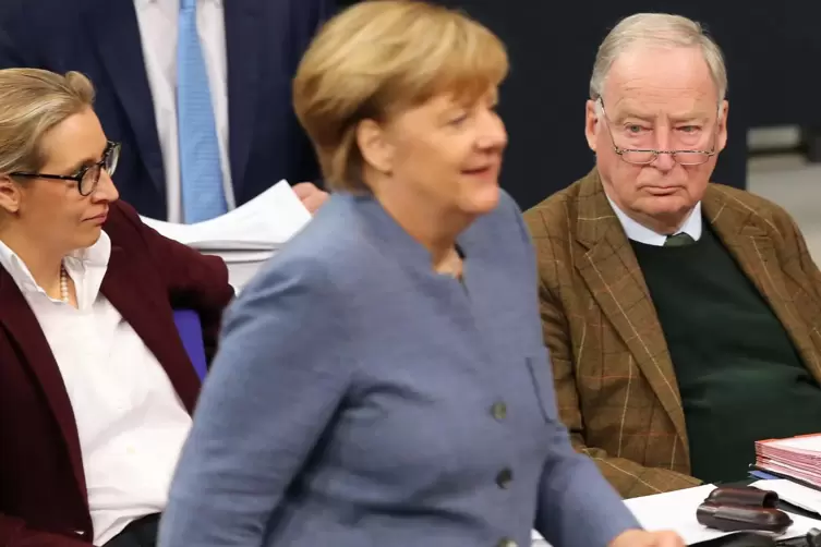 Skeptische Blicke im Hintergrund: Bundeskanzlerin Angela Merkel (CDU) geht 2017 während einer Sitzung des Deutschen Bundestags i