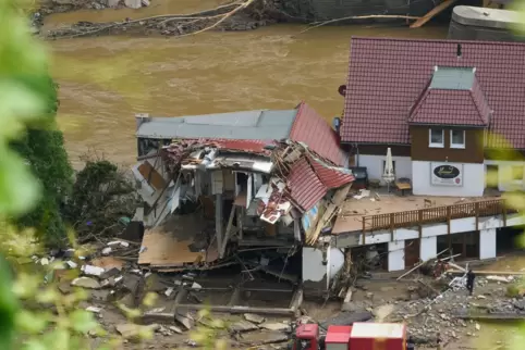 Ein Feuerwehrfahrzeug vor zerstörten Häusern im Ahrtal, wo die Aufräumarbeiten begonnen haben. 