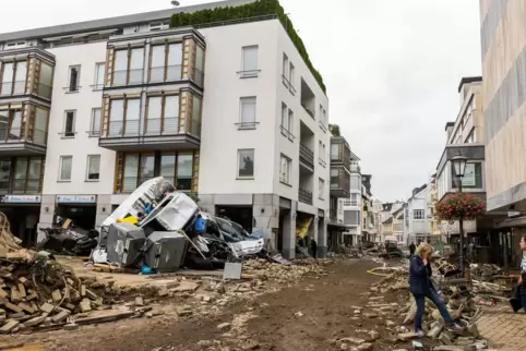Ein Stapel Autos und ein Müllcontainer liegen in Bad Neuenahr im nördlichen Rheinland-Pfalz auf einem vom Juli-Hochwasser vor we