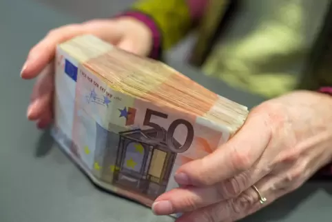 Brüssel plant neue Auflagen beim Einzahlen von Bargeld: Eine Bank-Mitarbeiterin hält am Schalter 5000 Euro in 50-Euro-Scheinen i