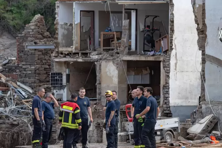 Mayschoß: Feuerwehrleute vor zerstörtem Gebäude. 