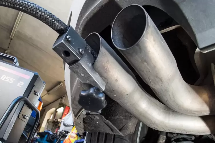 Ein Messschlauch eines Geräts zur Abgasuntersuchung für Dieselmotoren steckt im Auspuffrohr eines VW Golf 2.0 TDI in einer Werks