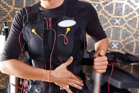 Beim EMS-Training trägt man eine Weste sowie Gurte an Oberschenkeln und Armen, die mit Elektroden versehen sind, die Strom in de