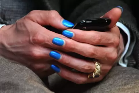 Hingucker: Ein Mann mit lackierten Fingernägeln tippt auf seinem Handy. 