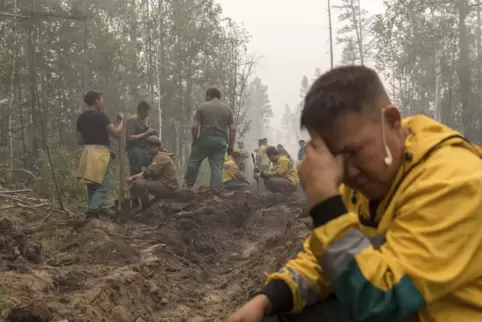 Die Helfer sind erschöpft. Sie haben einen Graben ausgehoben, um einen Waldbrand außerhalb des Dorfes Magaras 87 Kilometer westl