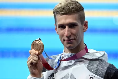 Florian Wellbrock zeigt seine Medaille. 