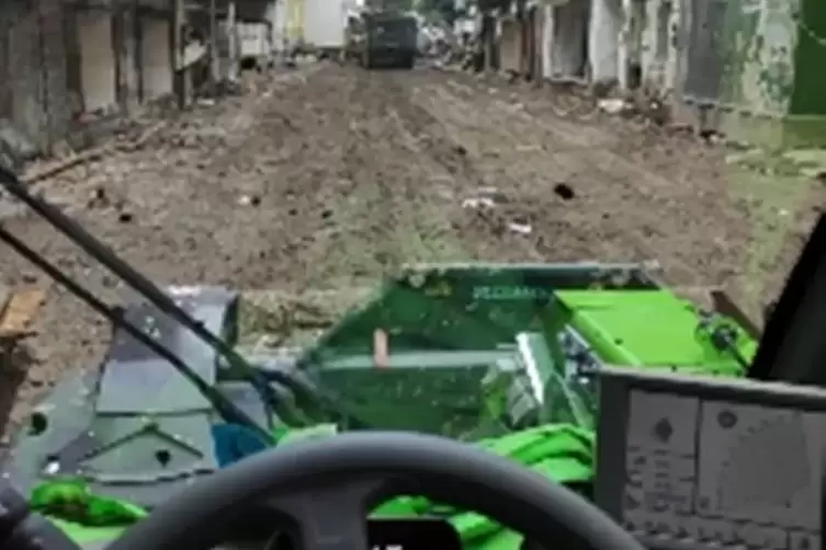 Die Helfer blick auf eine Stra&szlig;e voller Schlamm.