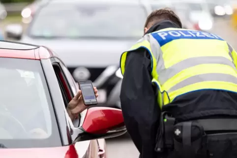 Lässt sich von einem Einreisenden dessen digitalen Impfpass zeigen: Bundespolizist bei einer Kontrolle in Grenznähe. 
