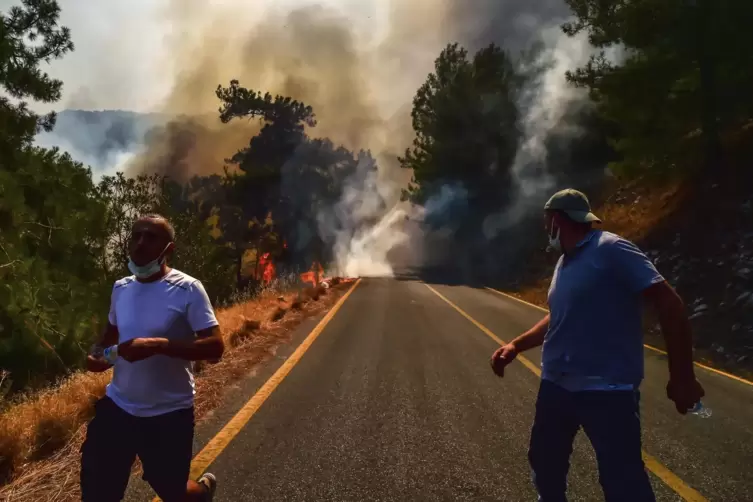 Zwei Menschen fliehen vor den Flammen in der Nähe der türkischen Stadt Bodrum. 