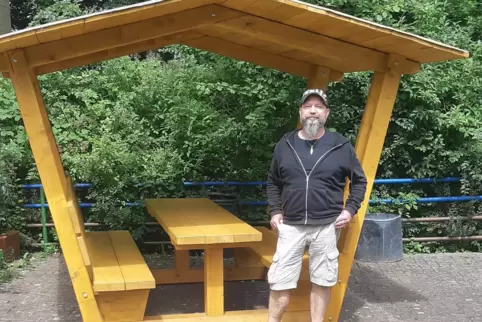 Harald Haaß vor der Sitzgelegenheit mit Überdachung. 