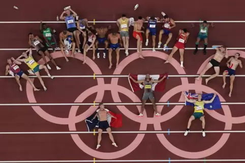 Die Athleten des Zehnkampfs posieren für ein Foto an den Olympischen Ringen. 
