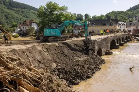 Ahrbrück: Ein Bagger verdichtet eine notdürftig geflickte Brücke über den Fluss Ahr.